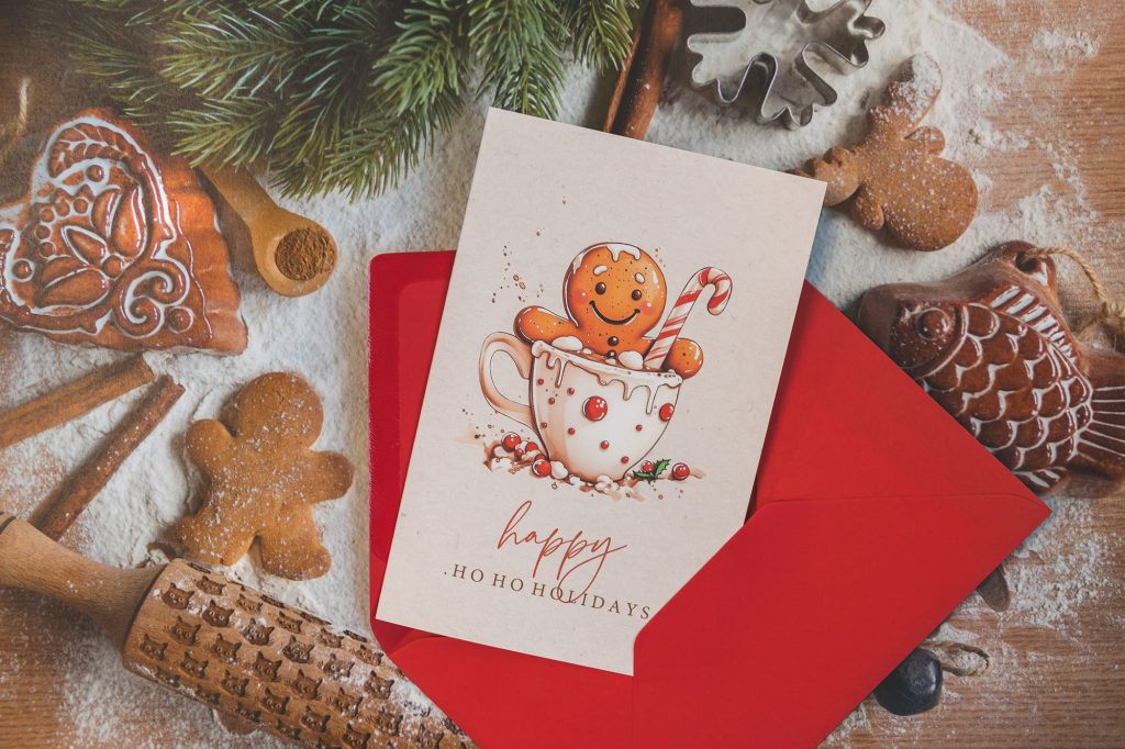 Coole Weihnachtskarte mit illustriertem Lebkuchenmännchen in einer Tasse und rotem Umschlag